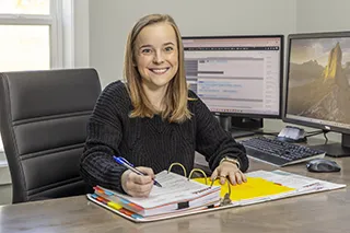 Price Services employee looking through a binder book